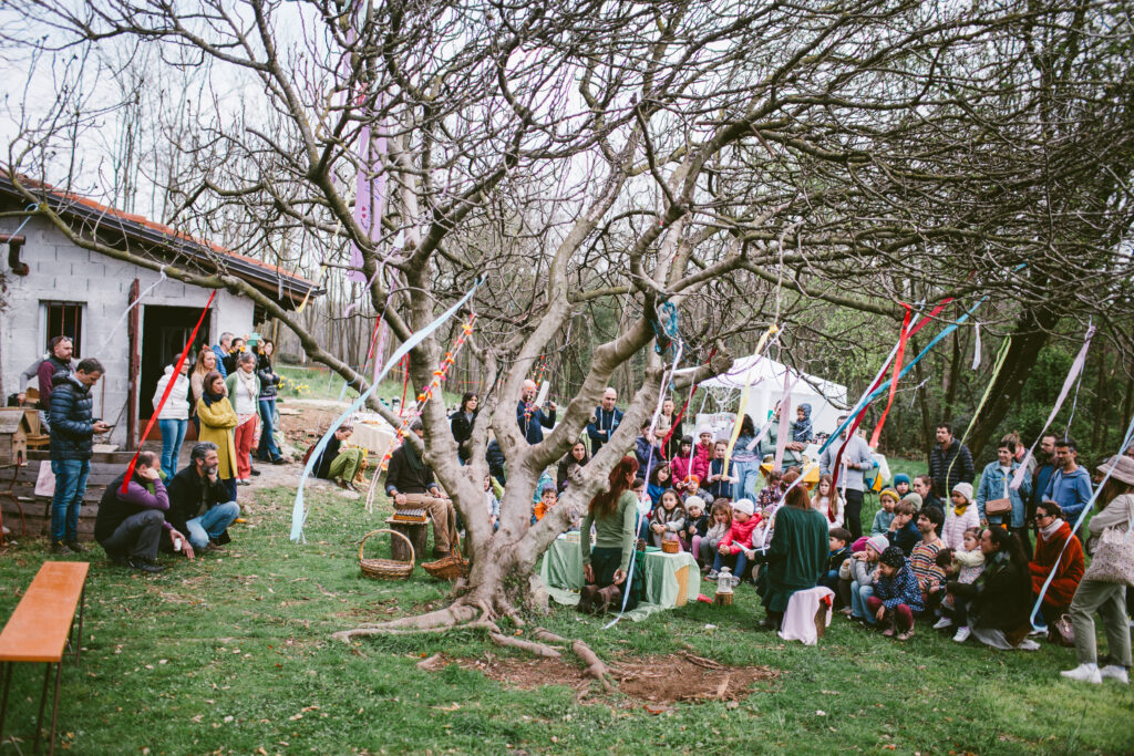 Famiglie riunite all’aperto intorno a un albero decorato